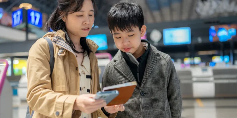Woman and boy checking boarding pass at airport